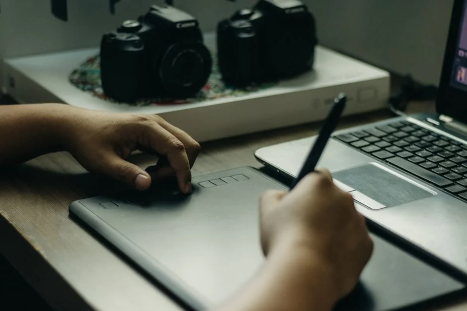 Gros plan sur un artiste qui crée des croquis de mode assis à un bureau à l’intérieur.