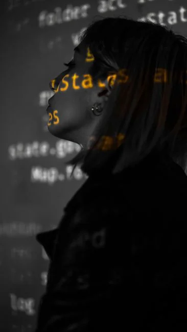 A silhouette of a fashion designer examining a creative mood board filled with fashion sketches and photos.